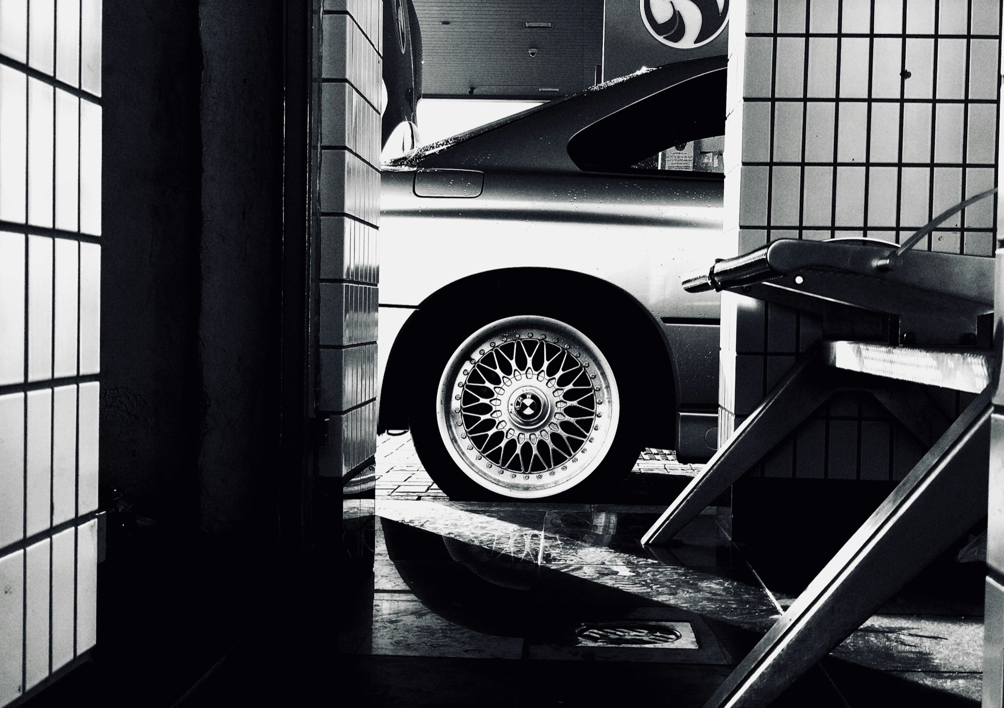 A car on an alignment rack with its front wheel on the turn plate