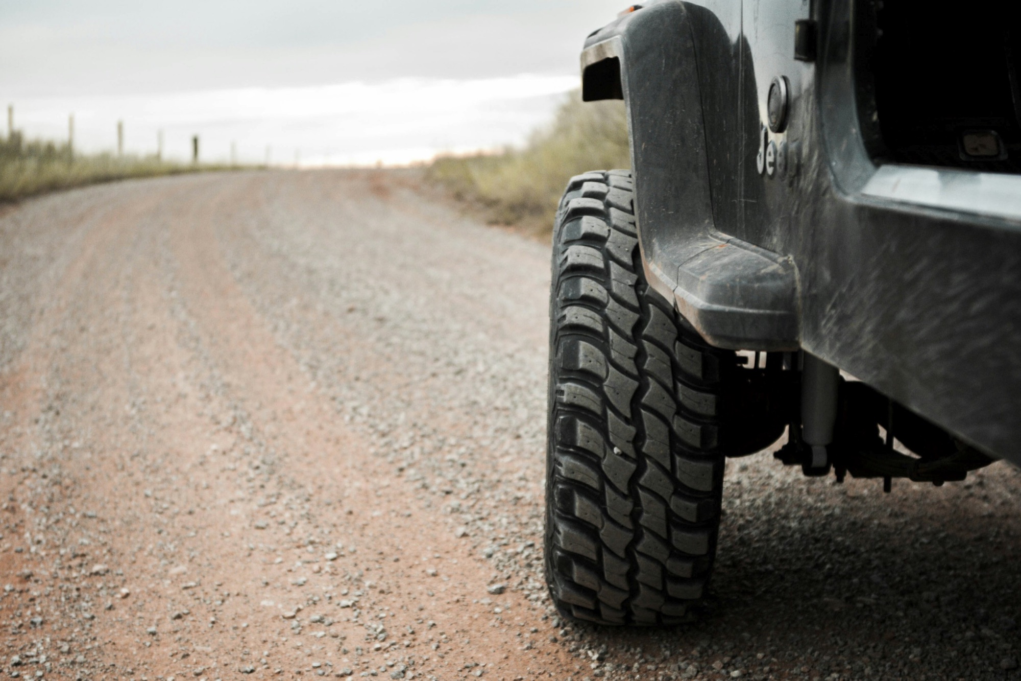 The big off-road tire and lifted fender of a truck on a dirt road