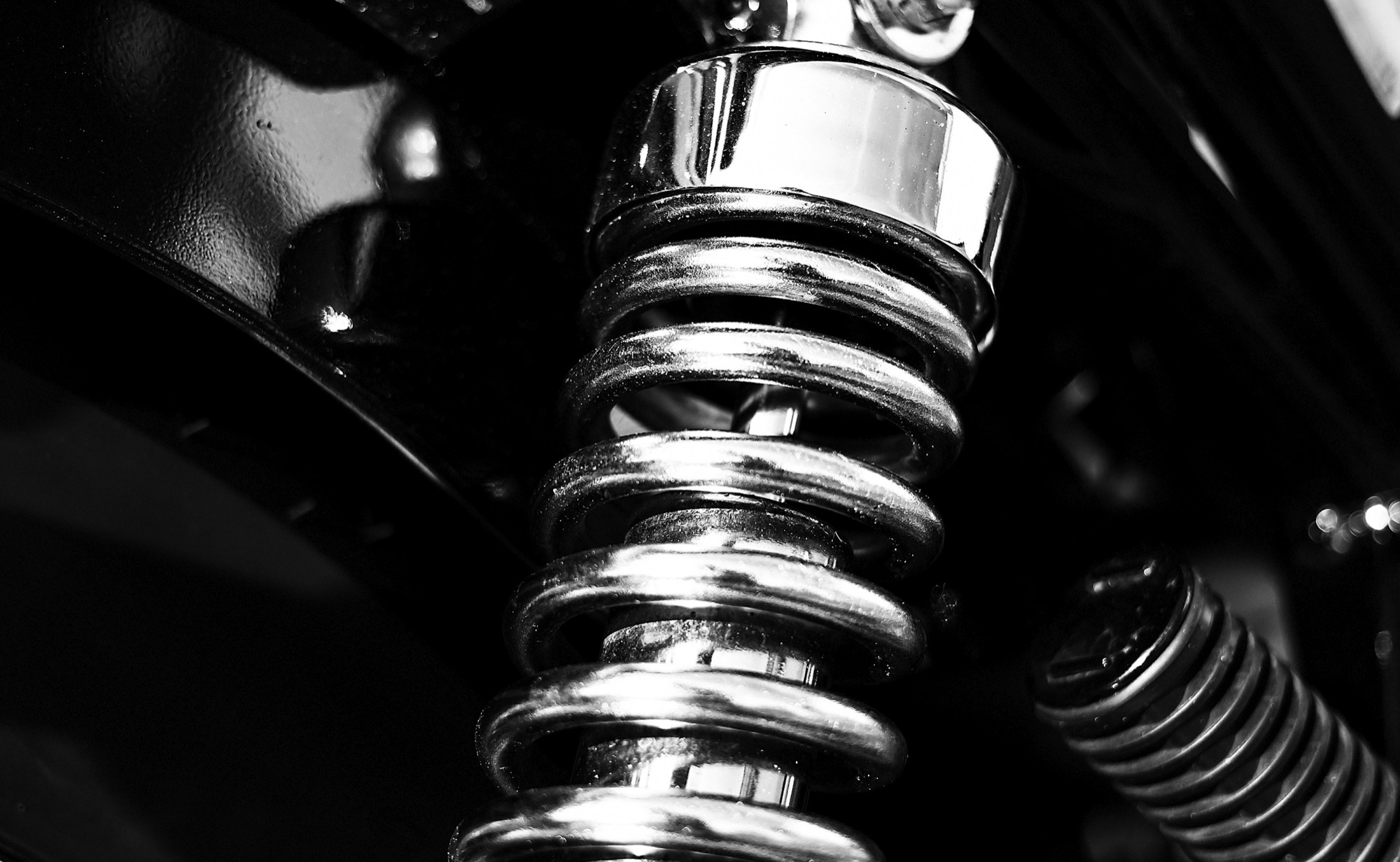 A chrome coil-over shock absorber on a car suspension
